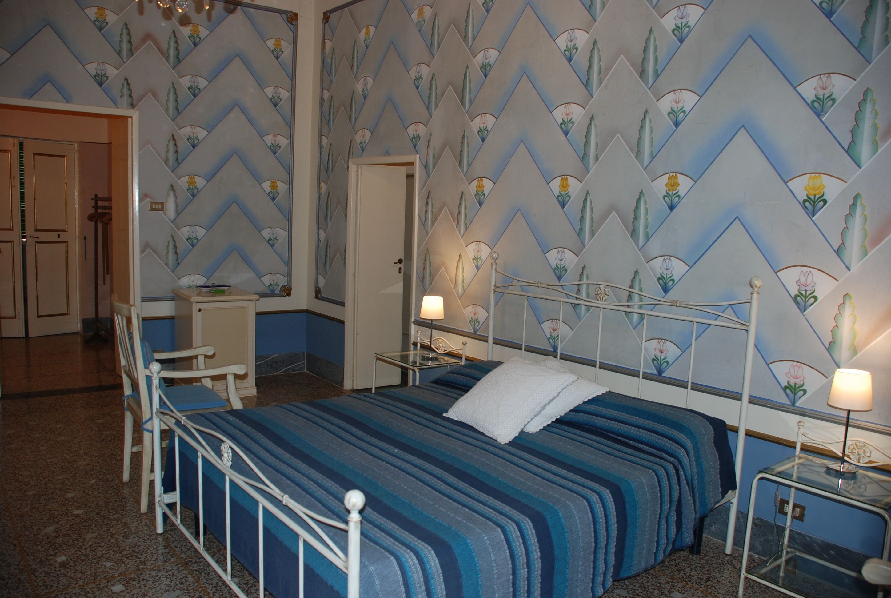 Un dormitorio con cama, mesitas de noche y un escritorio.