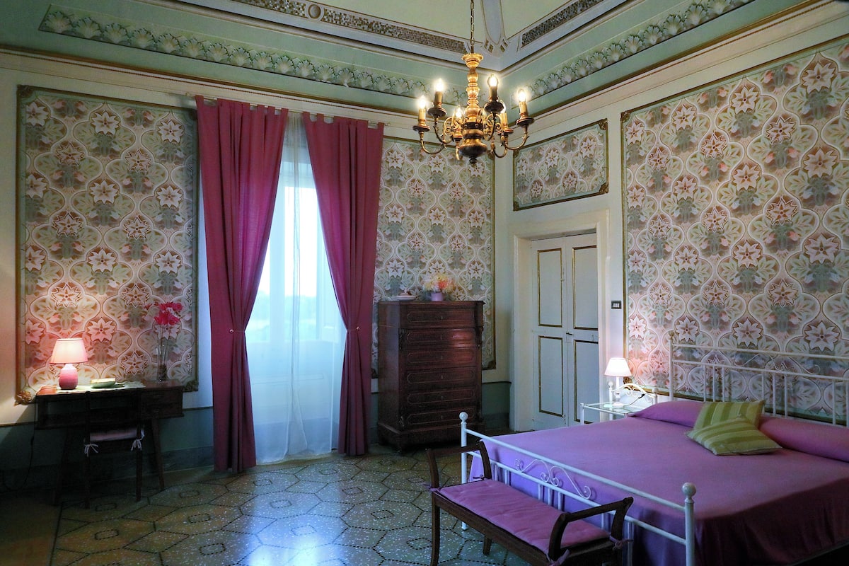 A room with a bed, a desk, a dresser, and a chair.