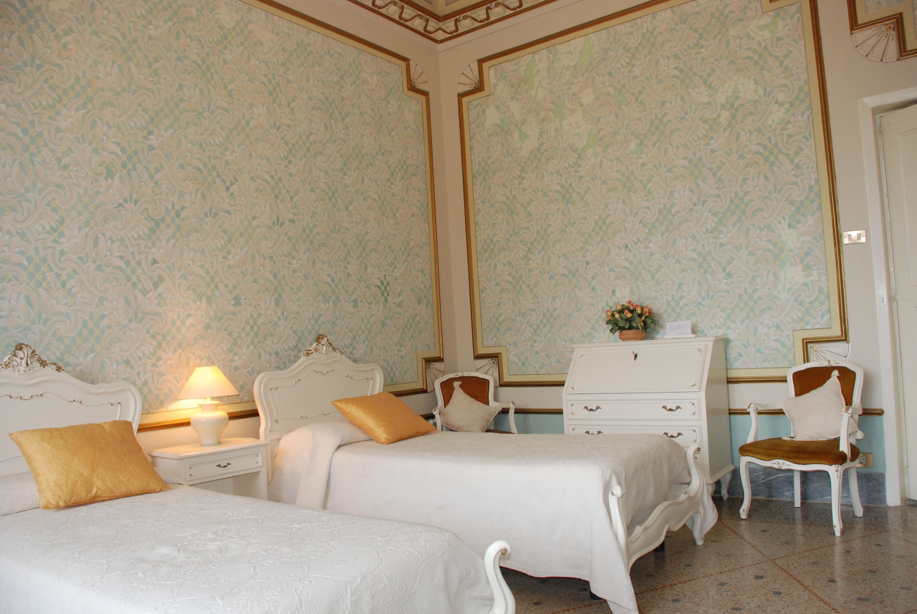 Una habitación de hotel con dos camas, un aparador, una silla y una lámpara.