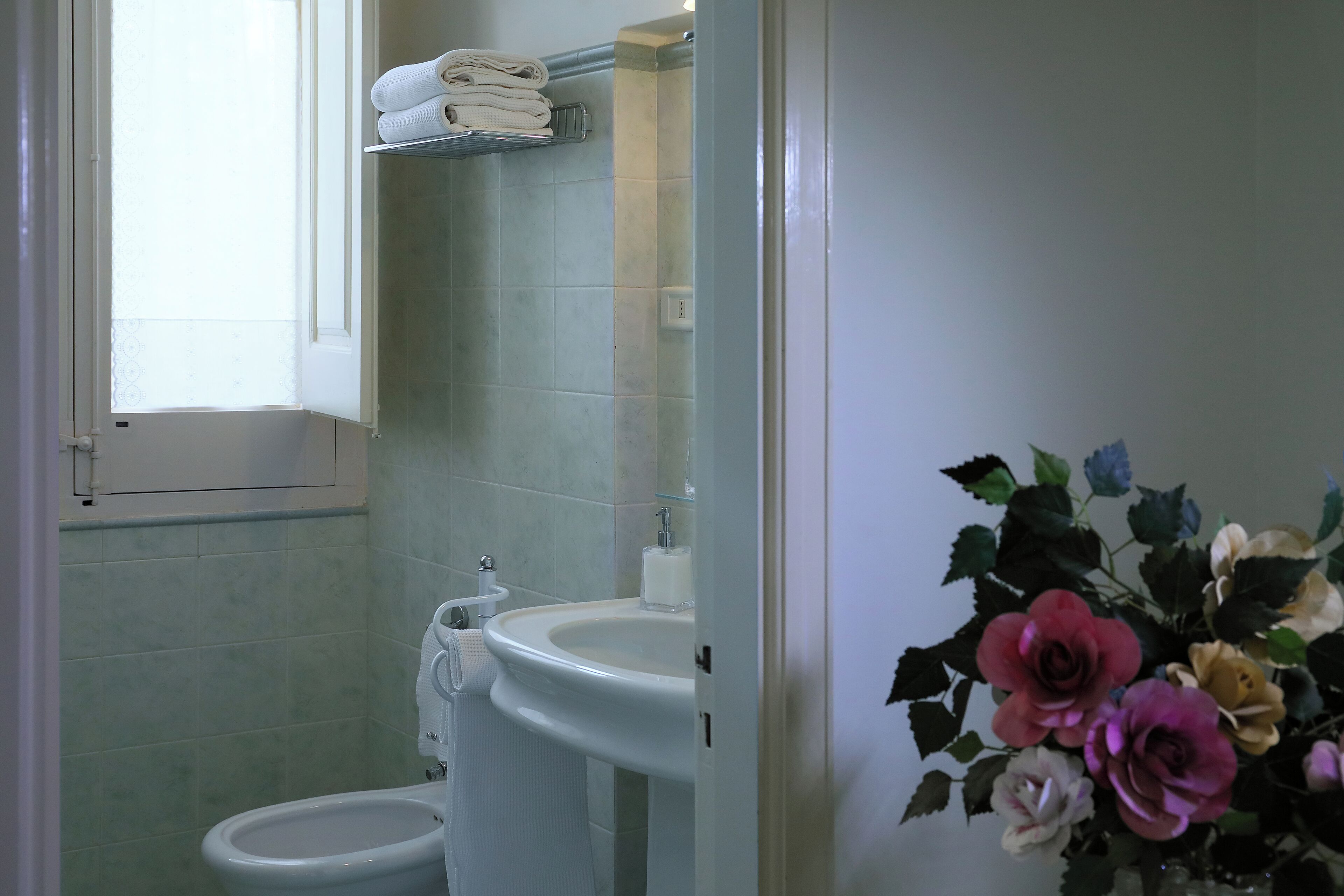 Un baño con inodoro, lavamanos y ventana.