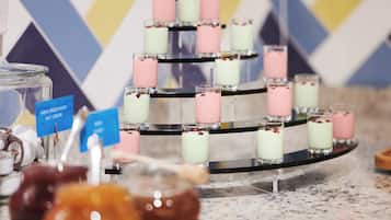 A tiered dessert display with various flavors, including a sign indicating 'NEW WINE CHOCOLATE' and 'NUT CREAM'.