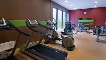 A gym with treadmills, elliptical machines, and weight equipment.