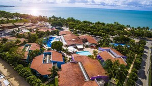An aerial view of a resort with multiple buildings, a swimming pool, and a beach. - Resort Arcobaleno All Inclusive (Porto Seguro)