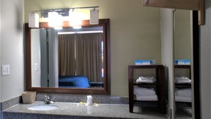 A hotel bathroom with a sink, mirror, and a towel rack. - Eastern Shore Motel (Daphne)