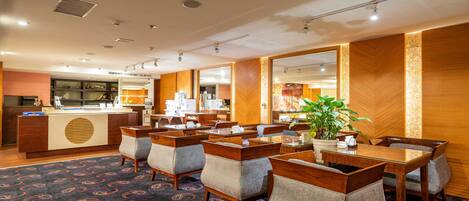 A hotel lobby with a reception desk, seating area, and a large mirror.