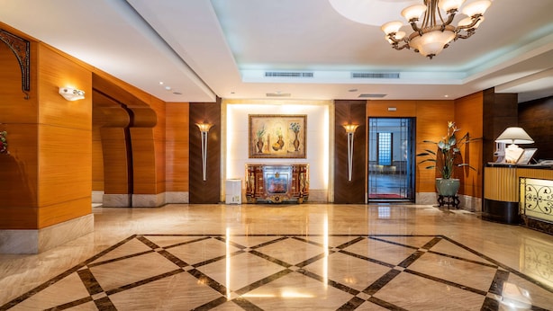 A spacious lobby with a polished marble floor, a grand chandelier, and a reception desk. - Waikoloa Hotel (Taipei)