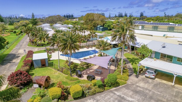 A residential area with a swimming pool, solar panels, and lush greenery. - Aloha Apartments (Norfolk Island)