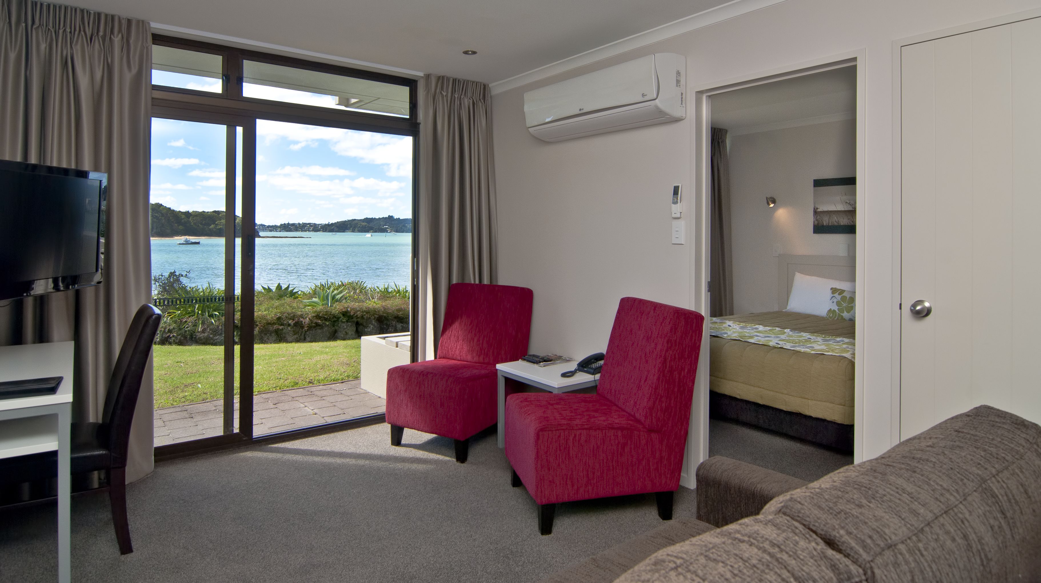 Deluxe Waterfront Suite Ocean | Living area | 32-inch flat-screen TV with satellite channels, TV