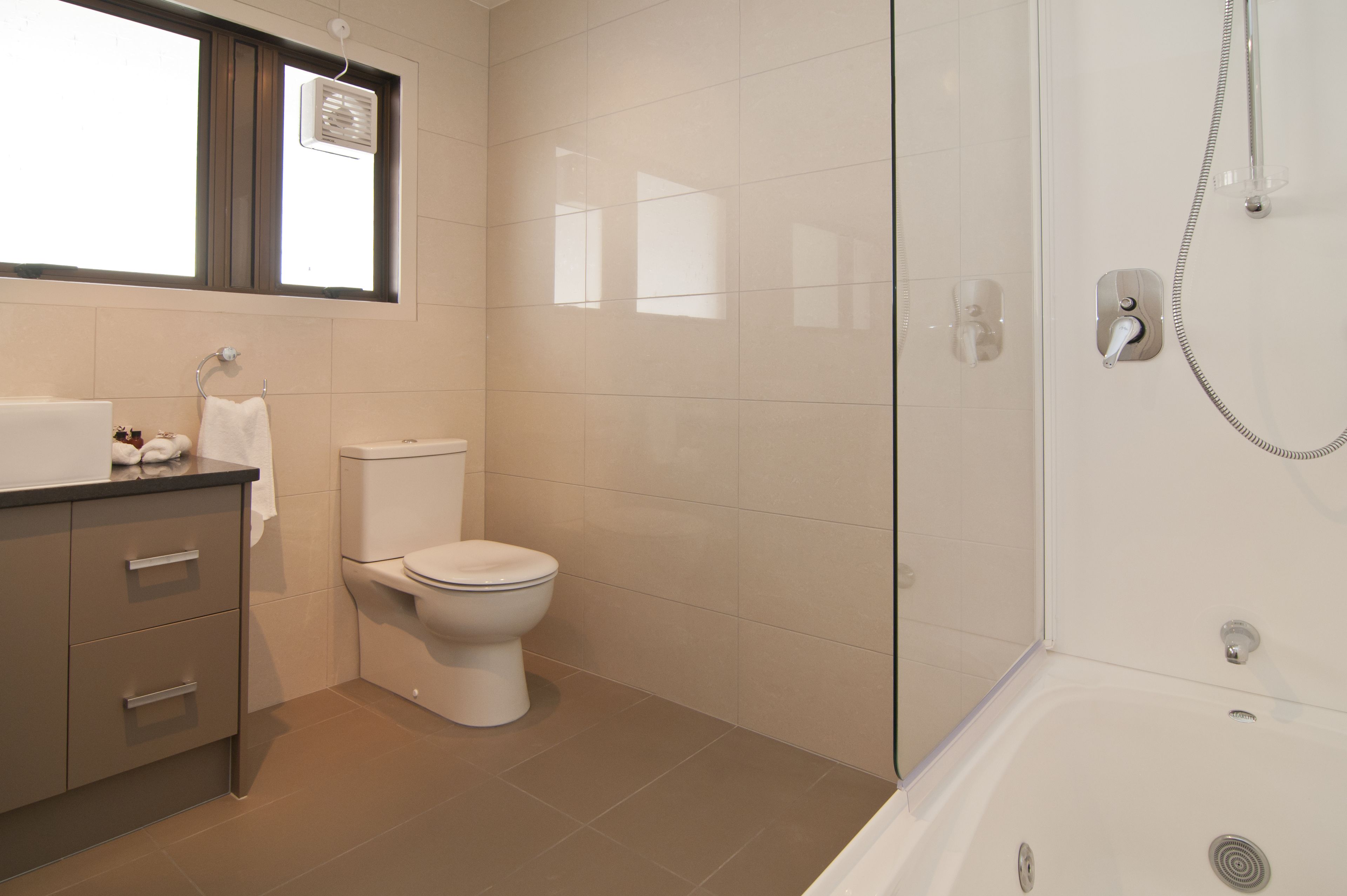 Une salle de bain moderne équipée de toilettes, d’un lavabo et d’une douche.