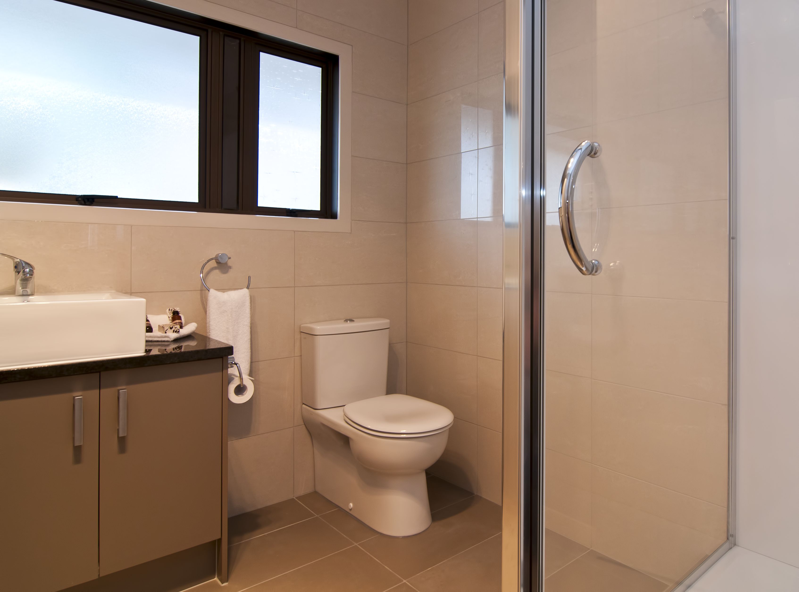 Une salle de bain moderne équipée de toilettes, d’un lavabo et d’une douche.