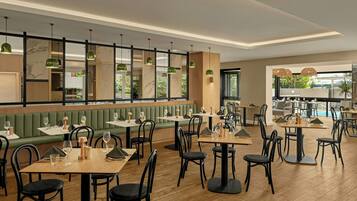 A restaurant interior with booths, tables, and hanging pendant lights.
