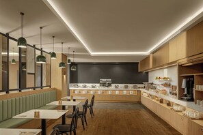 A modern restaurant with a long counter, seating area, and a kitchen in the background. - Courtyard By Marriott Darwin (Darwin)