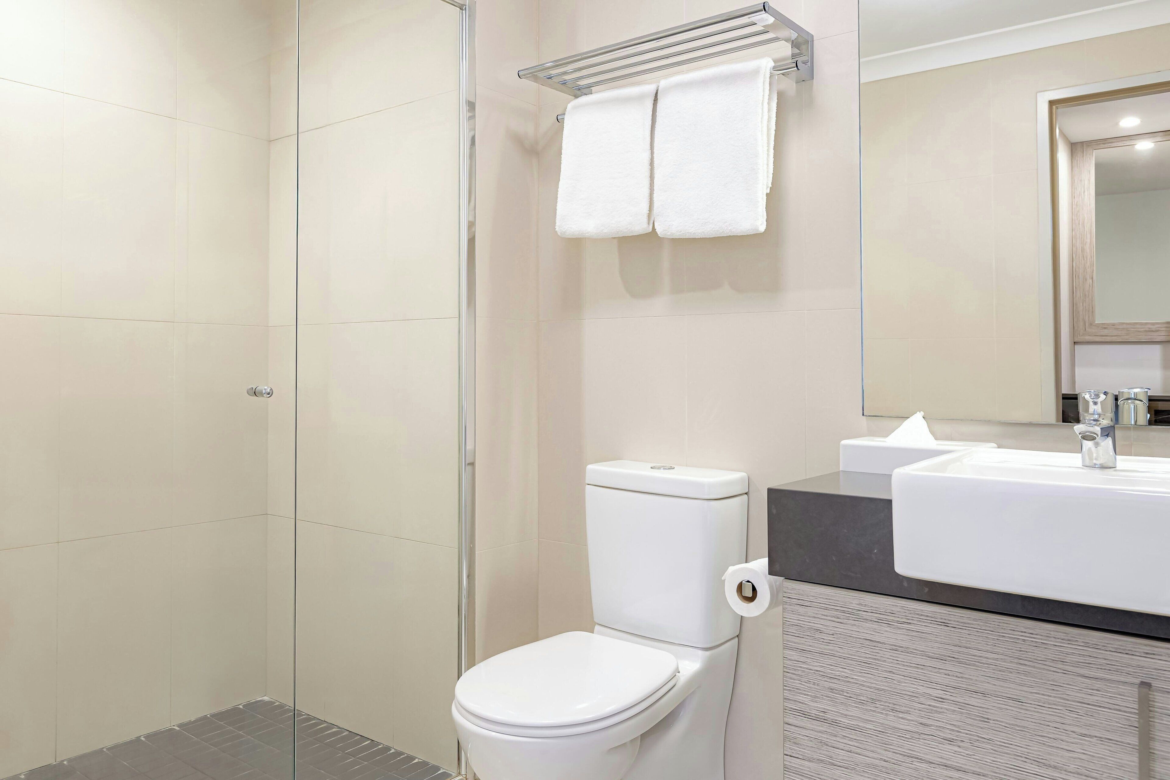 A modern bathroom with a toilet, sink, and shower.