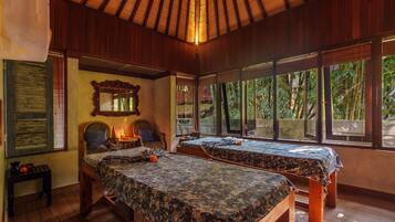 Two beds with matching headboards and footboards, a small table, and a lamp create a cozy atmosphere.
