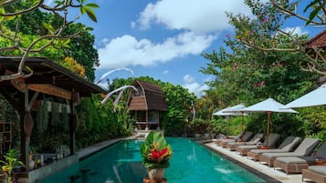 A swimming pool with lounge chairs and a decorative plant in the foreground.