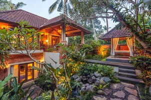 A tropical resort with multiple buildings, a stone pathway, and lush greenery.