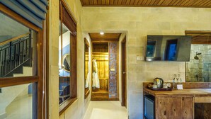 A hallway leading to a wooden kitchen area with a built-in oven and a large mirror above the counter. - Rama Phala Resort & Spa (Ubud)