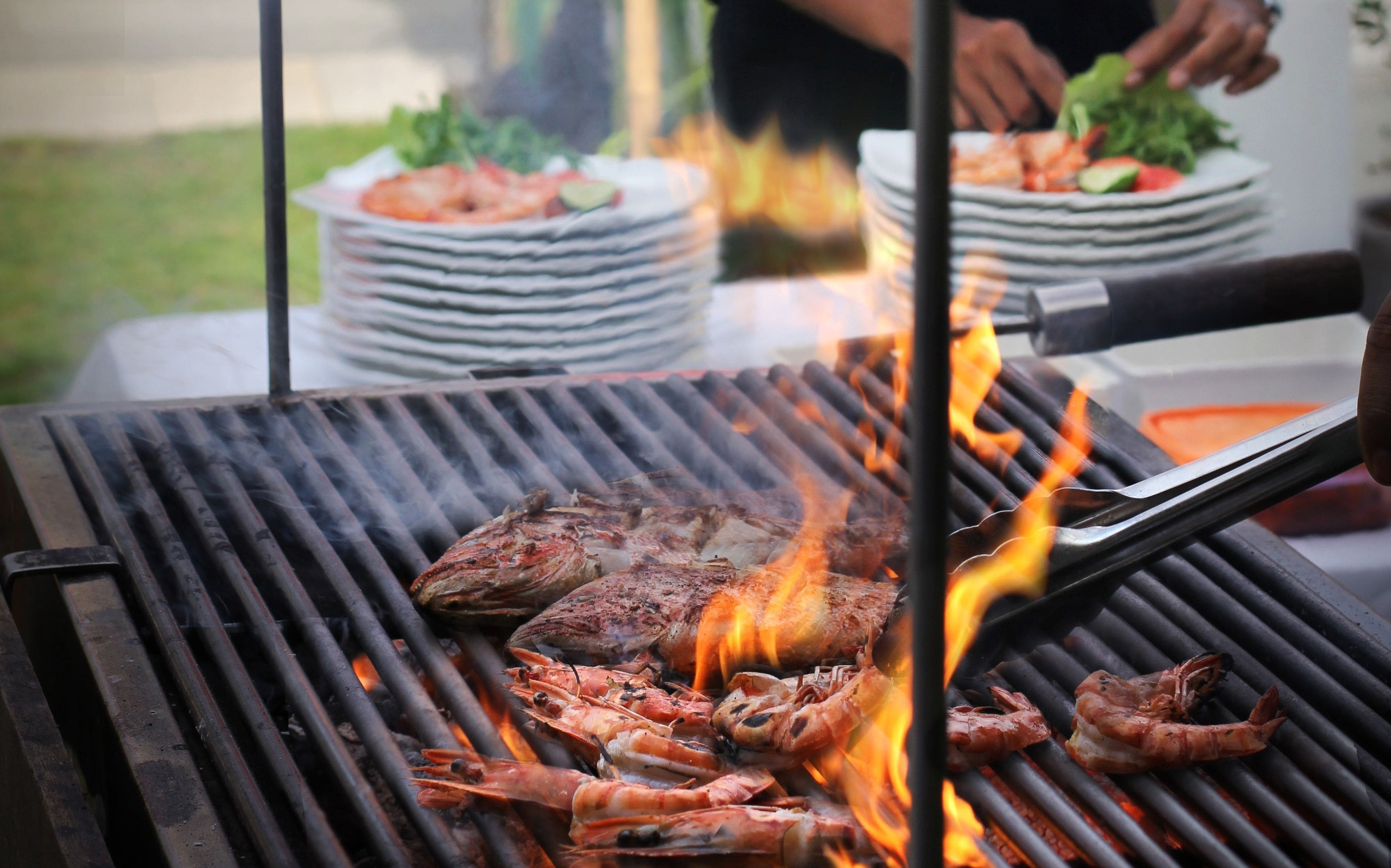 Una barbacoa amb marisc i carn a l'aire lliure.
