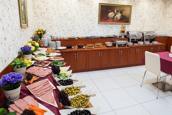 Montaje de bufé con diversos alimentos y una estación de café.