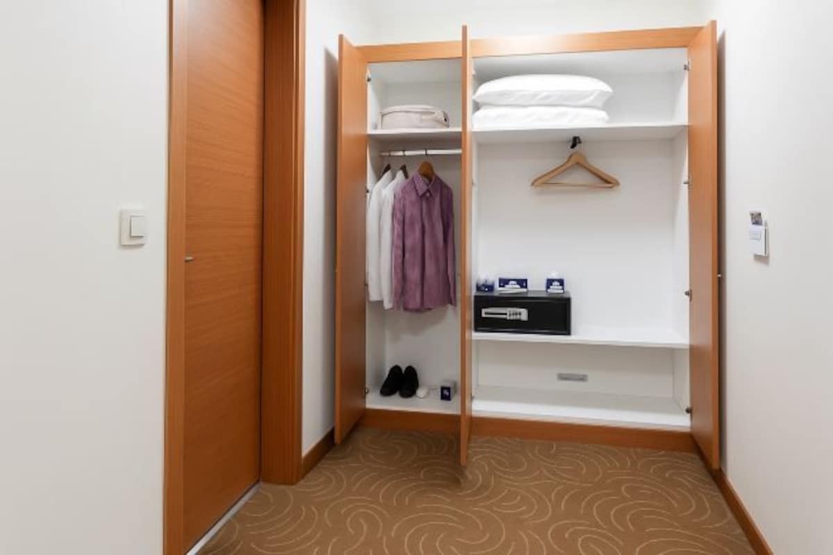 A walk-in closet with a hanging rack, shelves, and a shoe rack.