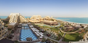 Un resort con diverse piscine, lettini e una spiaggia.