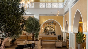 Un'ampia hall con un pianoforte a coda, comodi posti a sedere, un'area bar e un albero decorativo.