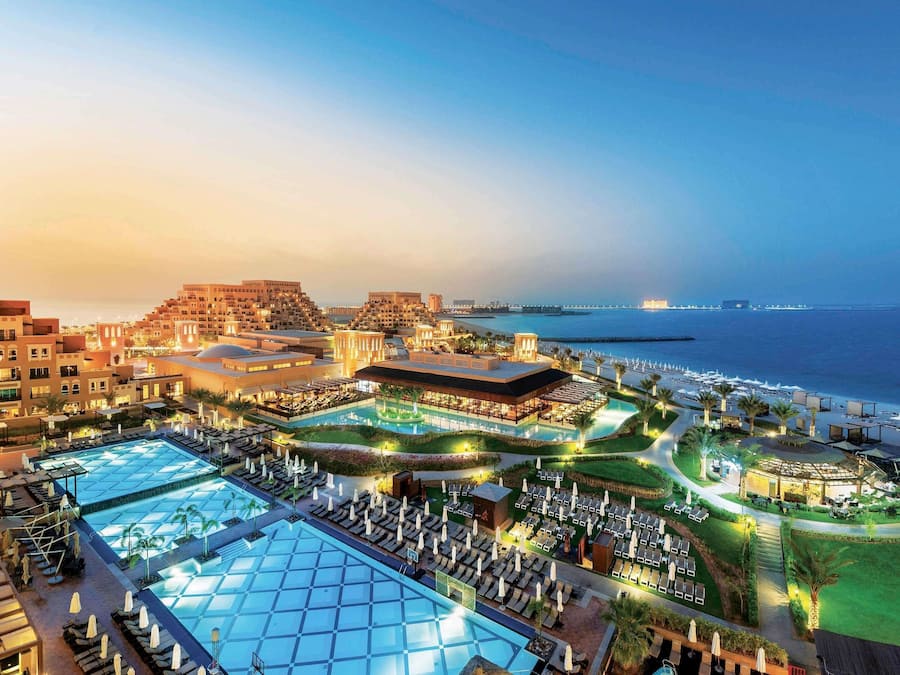 A resort with multiple swimming pools, a beach, and a view of the sea.