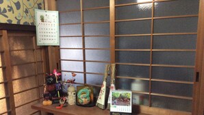 A wooden shelf with a calendar, decorative items, and a small calendar card. - Hanakiya (Kyoto)