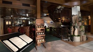 Un restaurant avec un décor intérieur en bois, un présentoir à vins et un escalier.
