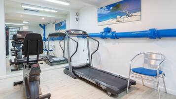 A gym with treadmills, a chair, and exercise equipment.