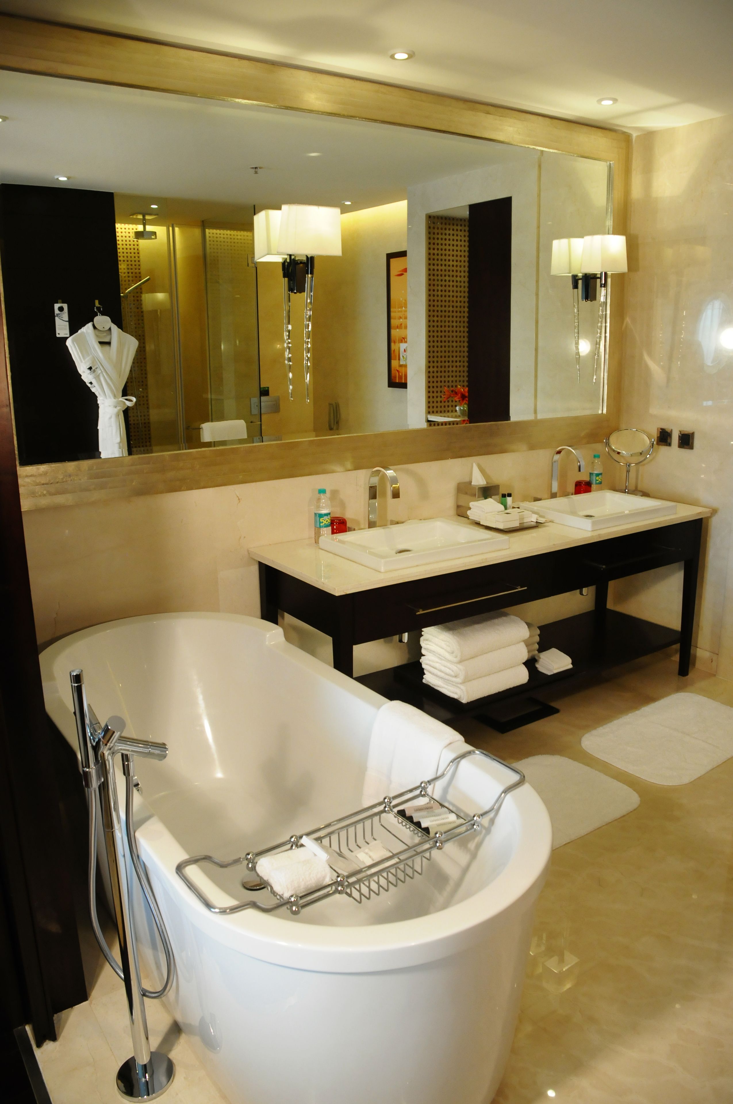 A modern bathroom with a freestanding bathtub, a double sink vanity, and a large mirror.