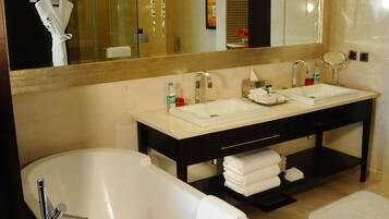 A modern bathroom with a freestanding bathtub, a double sink vanity, and a large mirror.