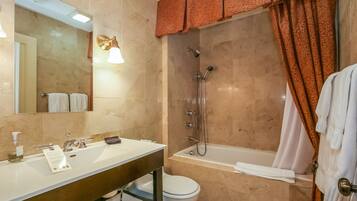 Un baño con lavamanos, espejo, inodoro y bañera.