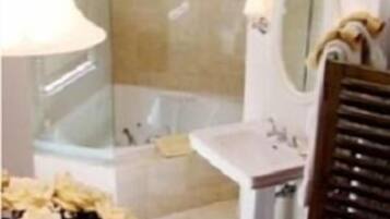 Un bagno con una vasca, un lavandino e uno specchio.
