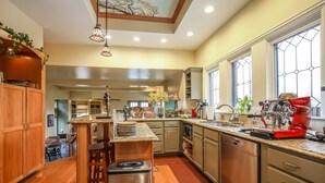 A modern kitchen with wooden cabinets, a stainless steel refrigerator, and a red coffee machine. - Harvey House Bed & Breakfast (Oak Park)