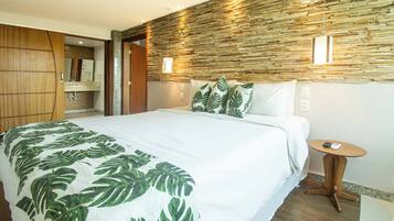 Habitación de hotel con cama, armario de madera, baño con espejo y pared con un diseño texturizado.