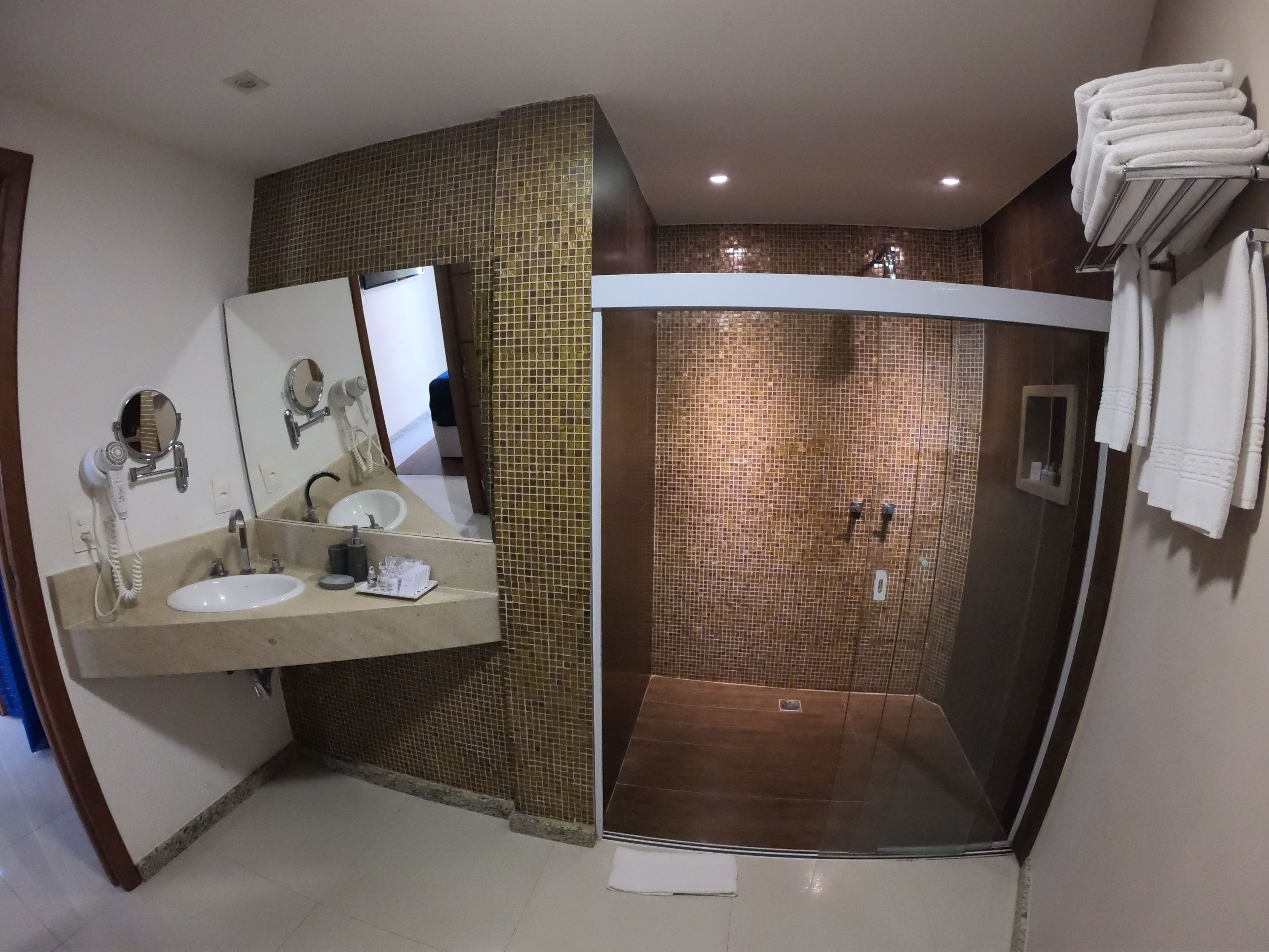 Ein Badezimmer mit Dusche, Waschbecken und Spiegel.