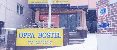 An OPPA HOSTEL sign in front of a building with a red playfun sign above the entrance.