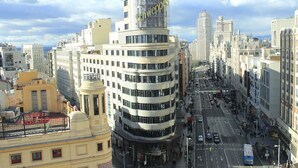 Un edificio de varios pisos con el logotipo de Vodafone en la parte superior, rodeado de otros edificios.