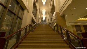 A grand staircase in a hotel lobby with glass railings and a chandelier. - Mandarin Plaza Hotel (Cebu City)