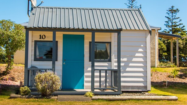A small, single-story building with a blue door and the number 10 on the front. - Whanganui Seaside Holiday Park (Whanganui)