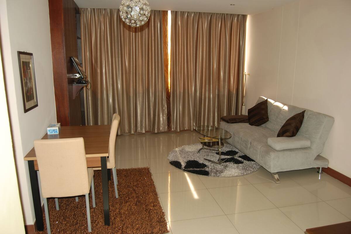 A modern living room with a dining table, sofa, and a round coffee table.