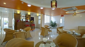 A hotel lobby with wicker furniture, a bar area, and a dining area with tables and chairs. - Van Mieu 2 Hotel (Hanoi)