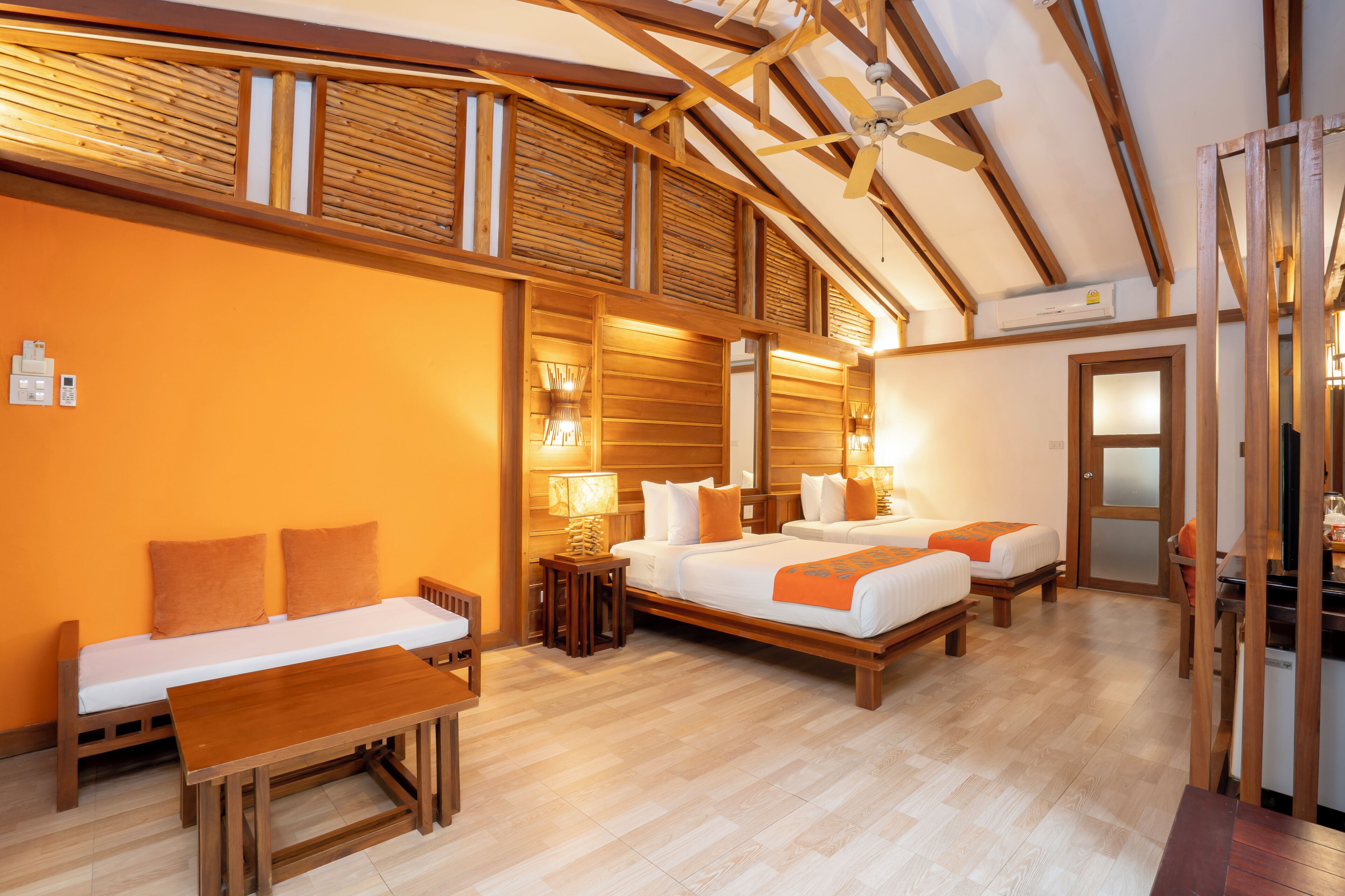 A hotel room with a wooden ceiling, a bed, a desk, and a chair.