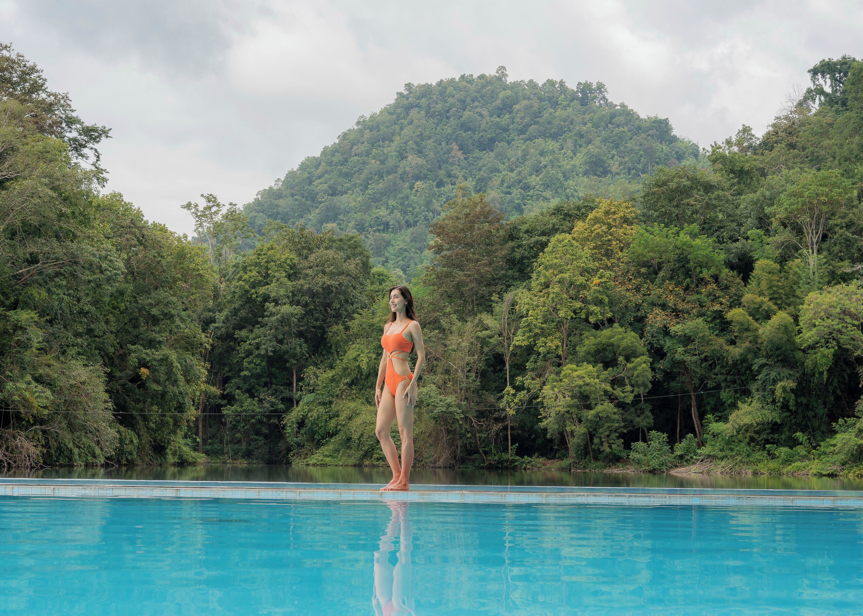 Una piscina al aire libre, sombrillas, sillones reclinables de piscina