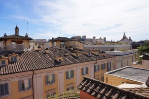 A view of a historic town with terracotta-tiled rooftops and traditional architecture.