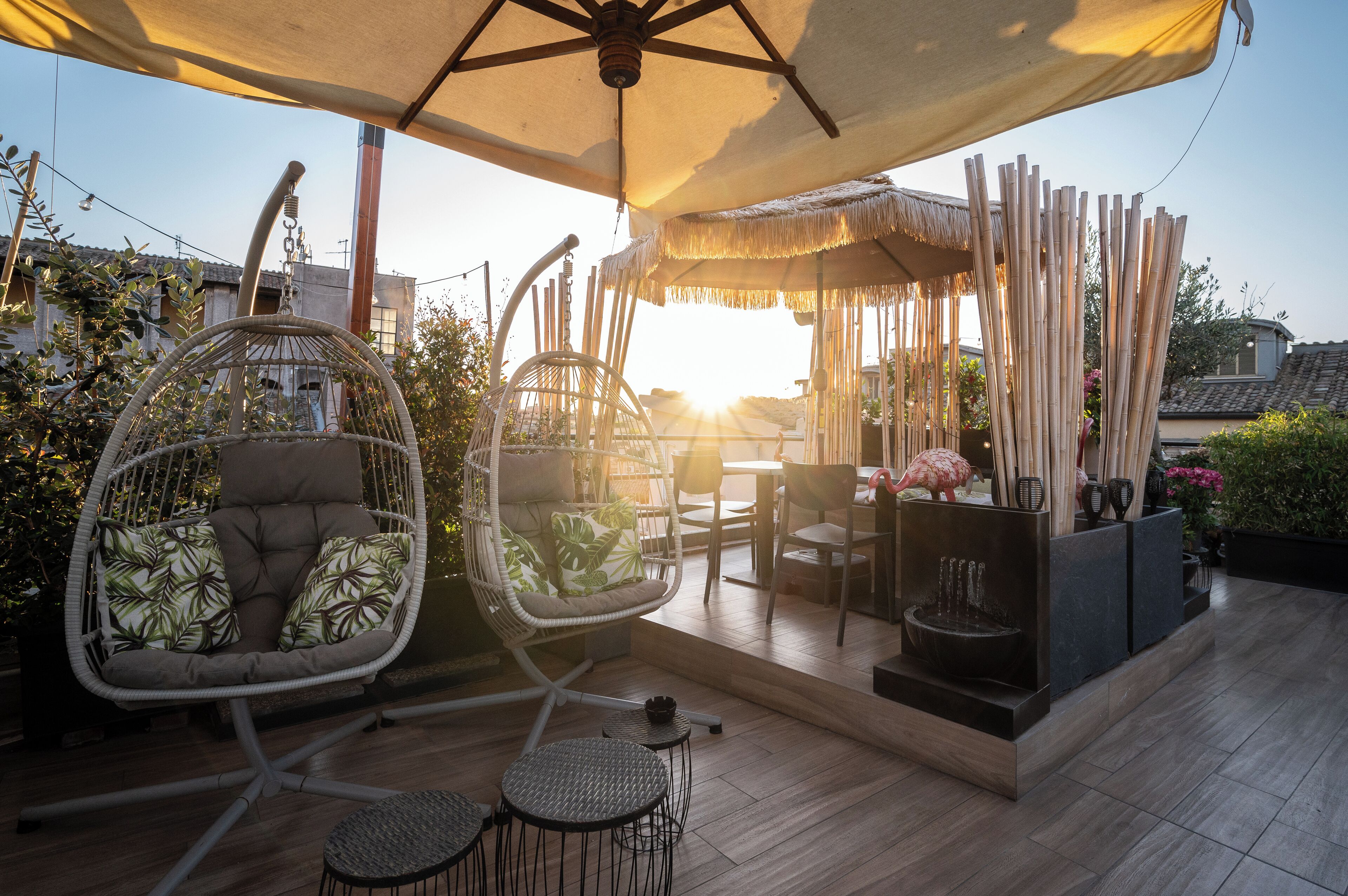 An outdoor patio with a hanging chair, a table, and a decorative bird sculpture.