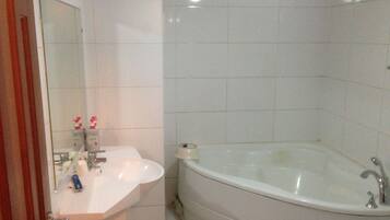 Un baño con lavamanos blanco, un espejo y una bañera.