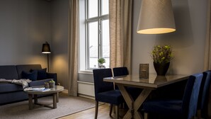 A modern living room with a sofa, a coffee table, and a dining area with chairs and a table. - Frogner House - Oscars gate (Oslo)
