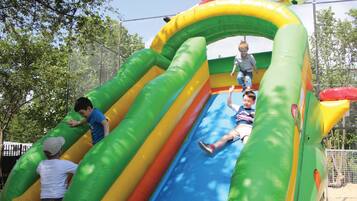 An inflatable play structure with slides and climbing areas.